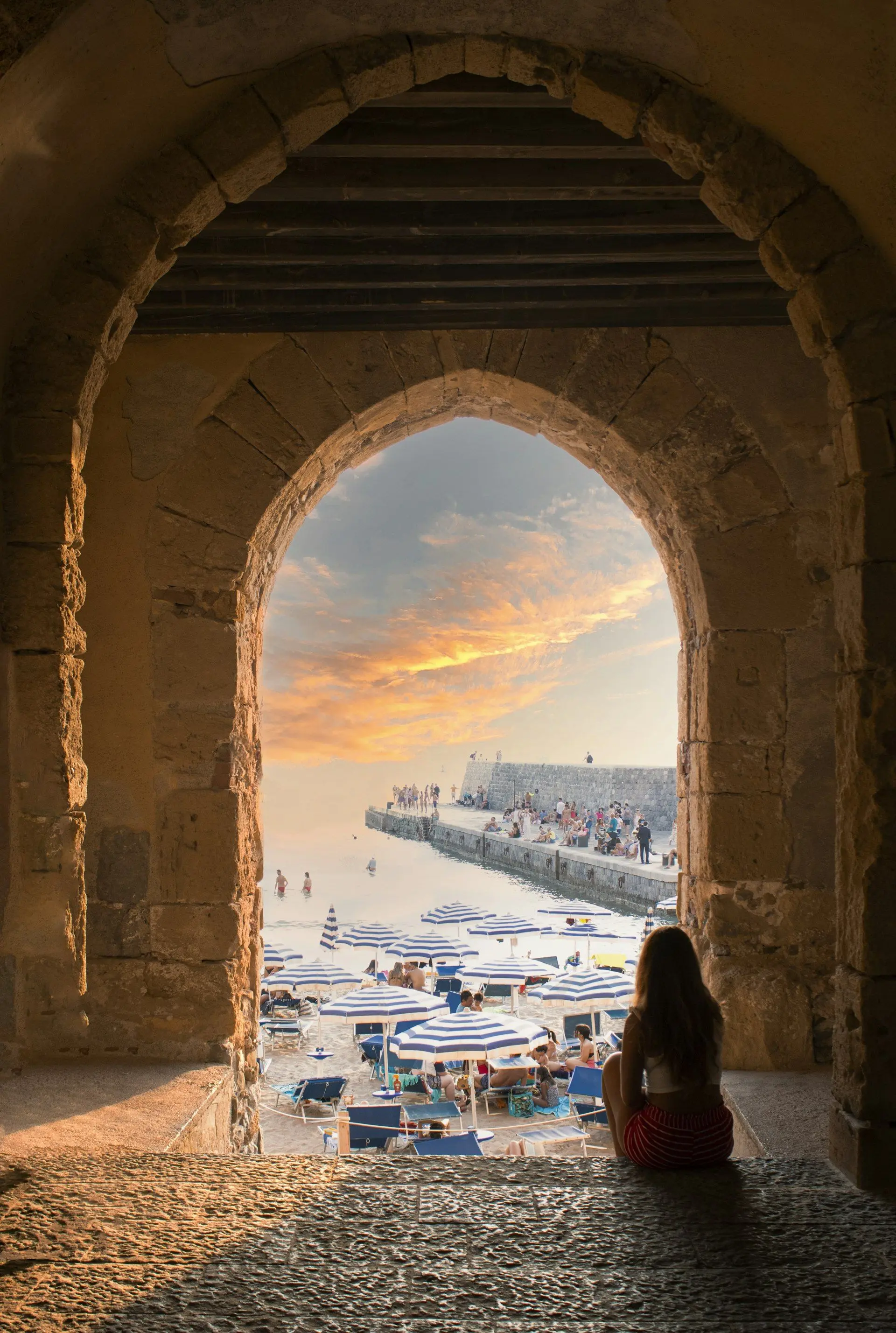 La spiaggia di Cefalù al tramonto vista da un arco del lungomare