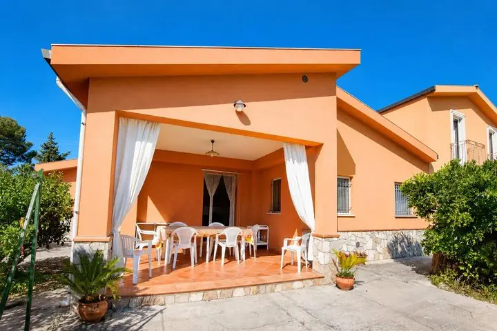 Veranda coperta con tavolo da pranzo e tende, Villa dei Limoni a Cefalù