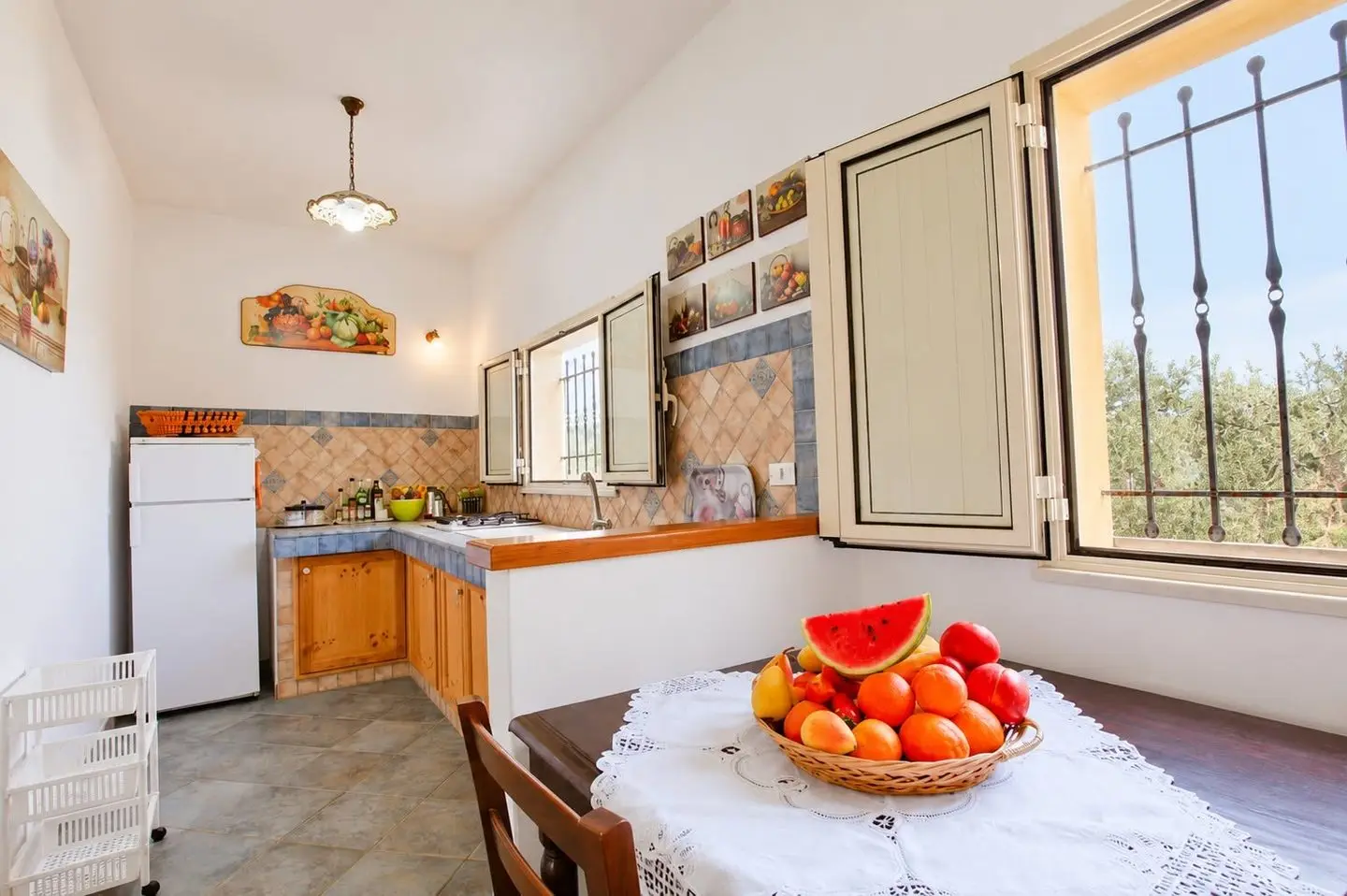 Cucina con tavolo e finestra sugli ulivi, Villa dei Mandarini a Cefalù